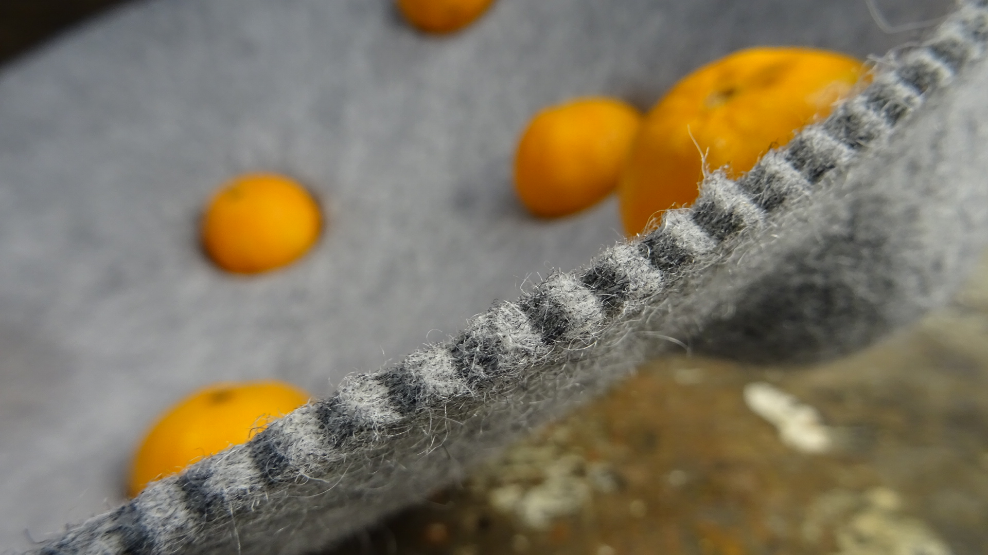 Graue Filzschale gefüllt mit Mandarinen